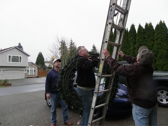 Kent, Jim (Patty's son) and Curtis putting up an enormous wreath.