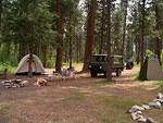 The campsite is ready for habitation. The green privey and tent are all set up.