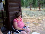 Karin, Curtis' sister, sits outside our cabin relaxing, reading and loving the views.